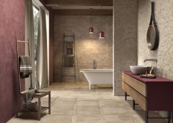 Prostorná rustikální koupelna s volně stojící vanou, umyvadlem na vínově laděné skříňce a cihlovým obkladem v teplých tónech.