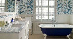 Elegantní provence koupelna s modrou volně stojící vanou, dvojumyvadlem a tapetou s modrobílým přírodním motivem