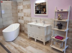 Koupelna ve stylu Provence s oválnou vanou, bílou skříňkou se dvěma umyvadly a otevřeným regálem na dekorace a ručníky