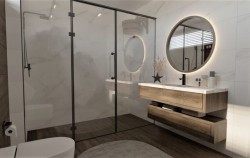 Koupelna s velkým skleněným sprchovým koutem v černém rámu, dřevěnou závěsnou skříňkou a kulatým LED zrcadlem nad zapuštěným umyvadlem