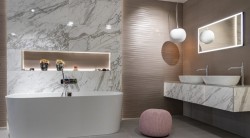 Luxusní koupelna s volně stojící vanou, dvojitým umyvadlem a mramorovým obkladem; ambientní osvětlení a designové závěsné lampy