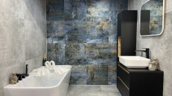 Moderní koupelna s šedo-modrými velkoformátovými obklady, akcentní stěnou v modrém kovovém dekoru, vanou a černým nábytkem s deskovým umyvadlem