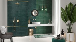 Luxusní koupelna s tmavě zelenými obklady, bílým závěsným pultem s umyvadlem, zlatými doplňky a zelenými závěsnými světly