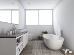 Moderní bílá koupelna s volně stojící vanou, obdélníkovým umyvadlem na mramorové desce; kubistické koupelnové doplňky