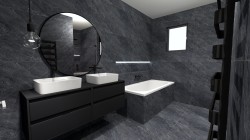 Koupelna v tmavém kamenném dekoru s dvojicí bílých umyvadel na černé skříňce, velkým kulatým zrcadlem a vestavnou vanou