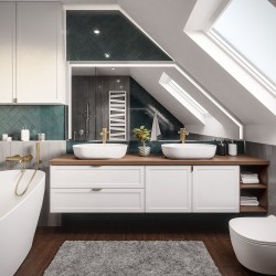 Podkrovní koupelna s dvěma umyvadly na dřevěné desce, oválnou vanou, zeleným obkladem pod šikminou a zlatými bateriemi