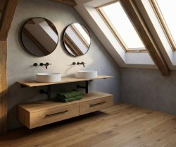 Umyvadlová sestava pod šikminou se dvěma kulatými zrcadly, dvěma deskovými umyvadly a závěsnou dřevěnou skříňkou na dřevěné podlaze